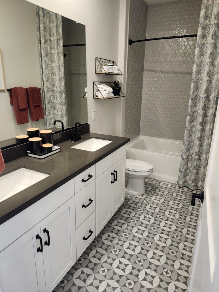 Remodeled bathroom with double sinks and tiled shower.